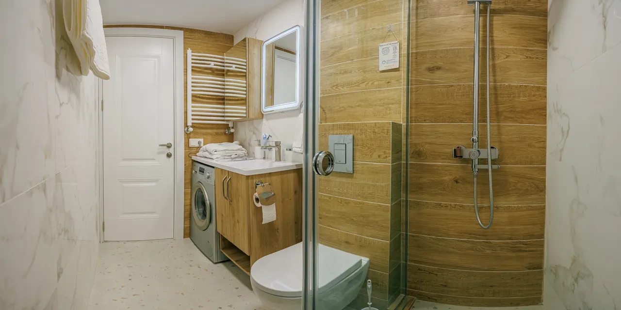 Orange Cat bathroom with shower and washing machine
