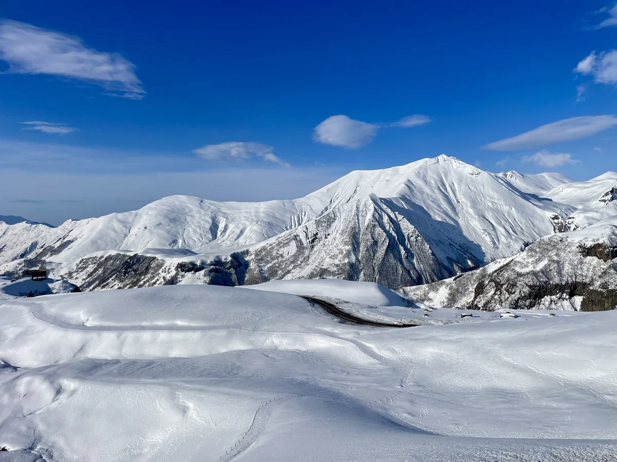 Snow-covered mountains and a road on the Upper Lars route